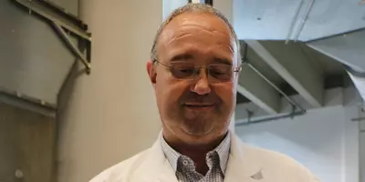 PR-Referent Alexander Dalli hält ein getrocknetes Tabakblatt in seinen Händen.