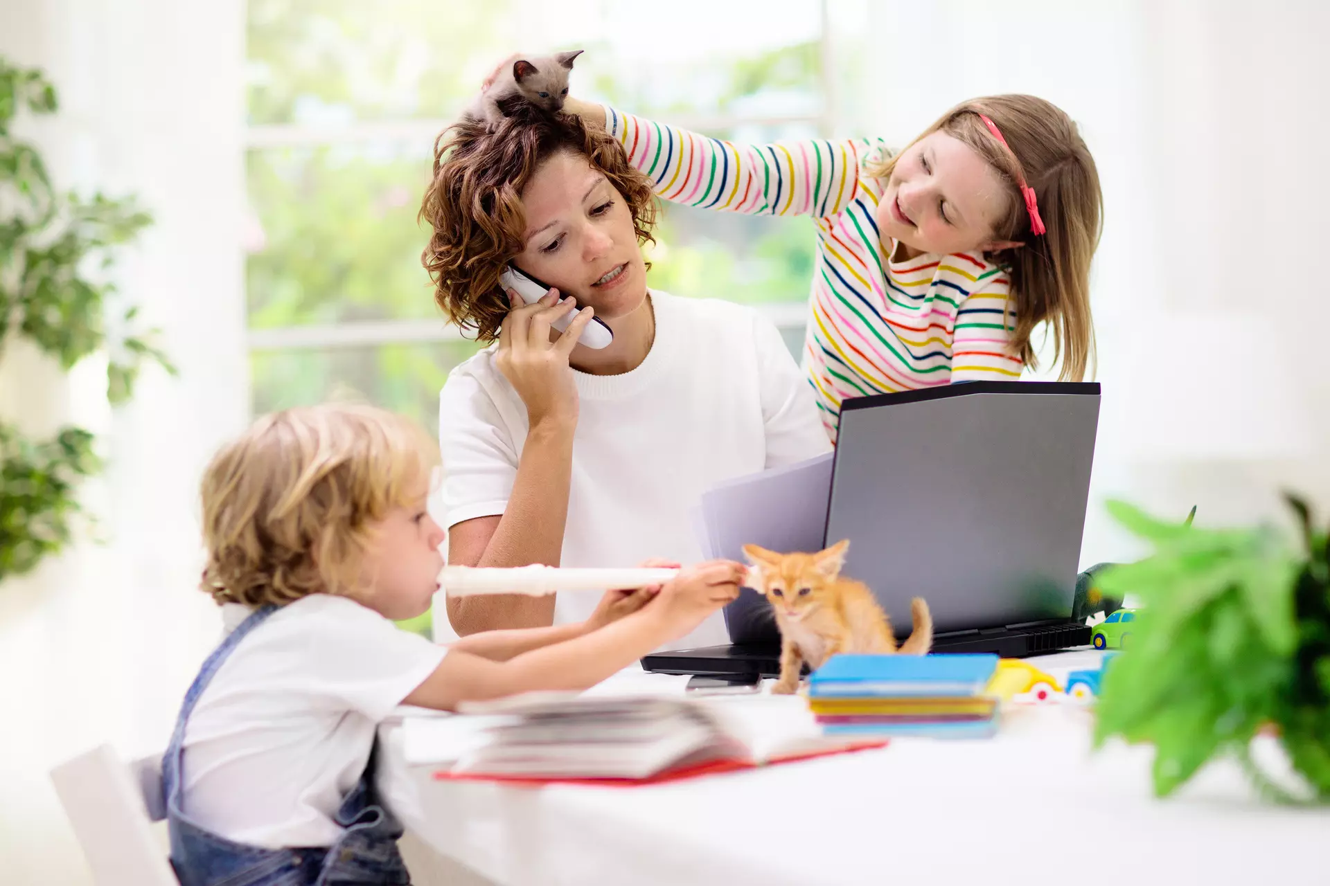 Mutter arbeitet im Homeoffice und versucht alles unter einen Hut zu bekommen: Arbeit, Haushalt und die Kinderbetreuung. Die 4-Tage-Woche würde Erleichterung schaffen.