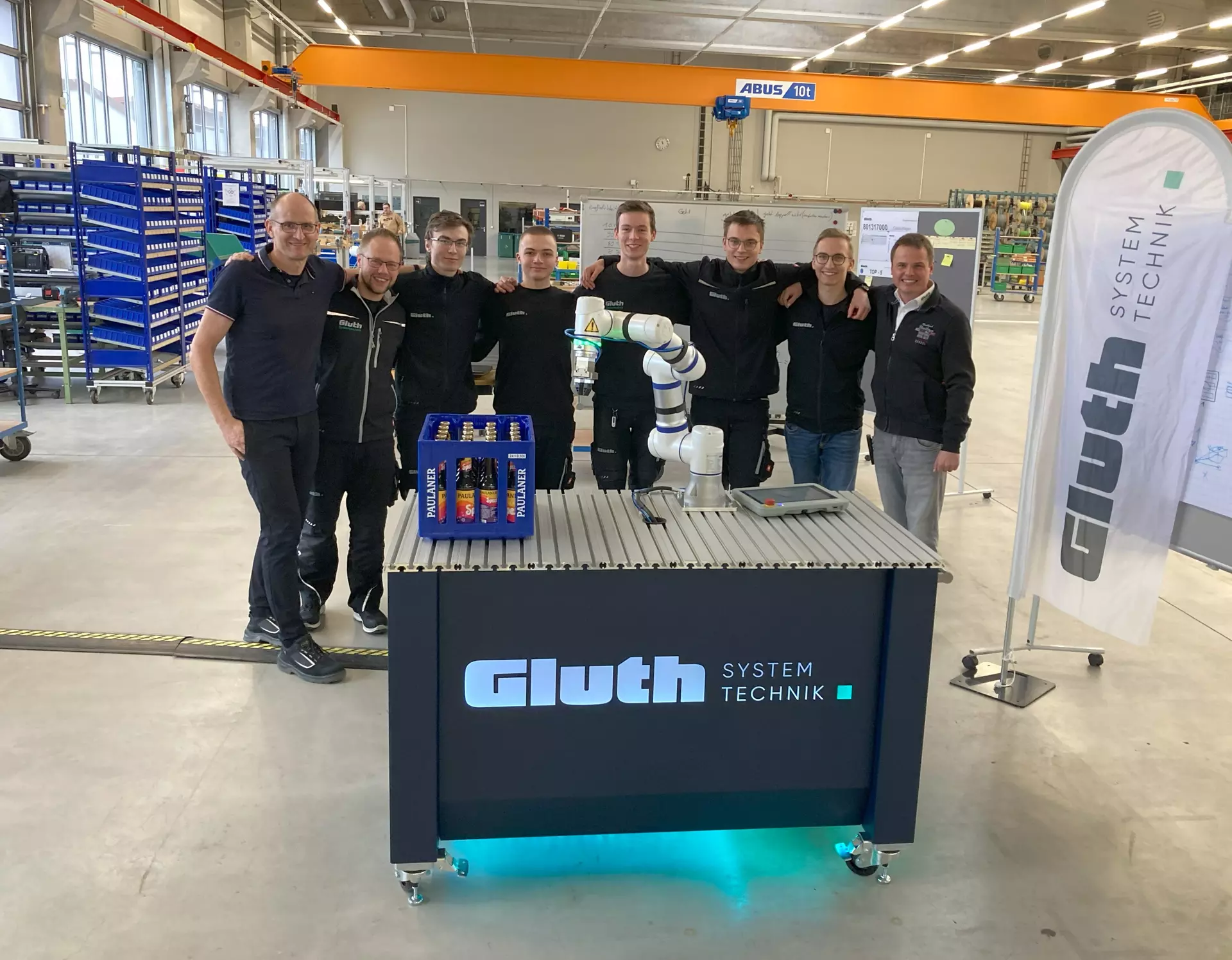 Technischer Leiter Thomas Hohenwarter, Ausbildungsleiter Michael Bauer, das Azubi-Projektteam und Geschäftsführer Johannes Sigl (v.l.) nach der erfolgreichen Abnahme des Cobot-Wagen-Projekts. Foto: Gluth GmbH
