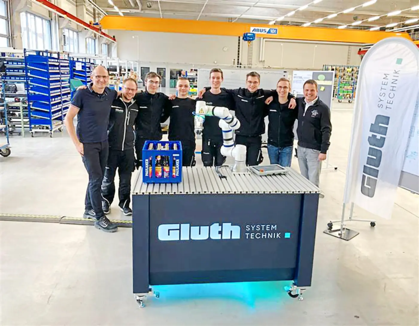 Technischer Leiter Thomas Hohenwarter, Ausbildungsleiter Michael Bauer, das Azubi-Projektteam und Geschäftsführer Johannes Sigl (v.l.) nach der erfolgreichen Abnahme des Cobot-Wagen-Projekts.  Foto: Gluth GmbH